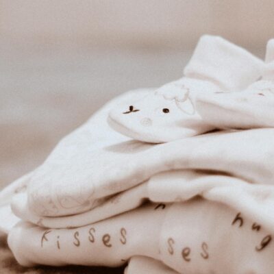 Close-up of soft white baby clothes with cute animal patterns, ideal for newborn comfort.